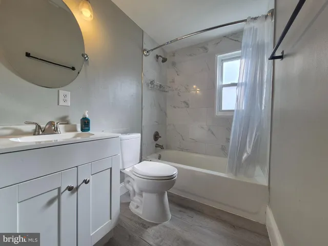 a bathroom with a shower sink vanity mirror and toilet