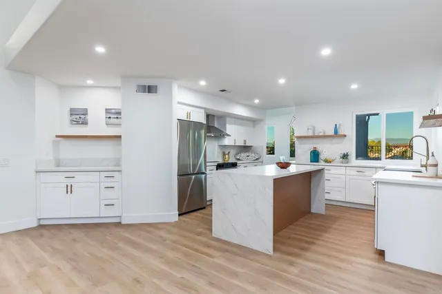 a kitchen with white cabinets and stainless steel appliances