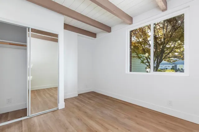 an empty room with windows and closet