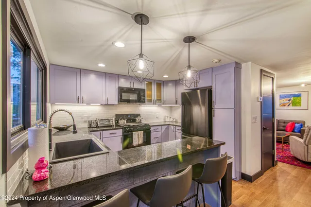 a kitchen with stainless steel appliances granite countertop a sink refrigerator and cabinets