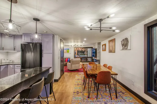 a view of a dining room with furniture a chandelier and wooden floor