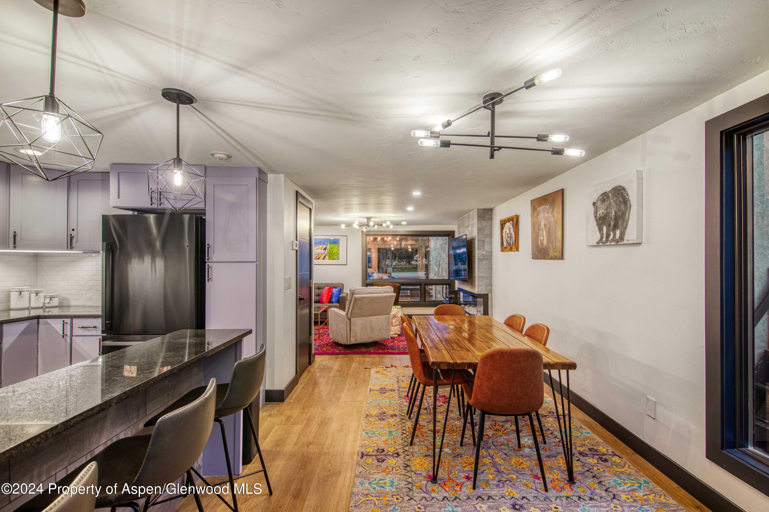 1501 Maroon Creek Road, Unit 6 Aspen, CO 81611 - Photo 37 of 48 a view of a dining room with furniture a chandelier and wooden floor