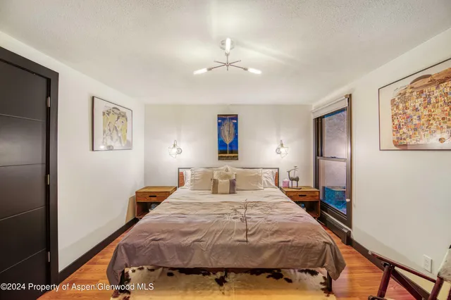 a bedroom with a large bed and a chandelier