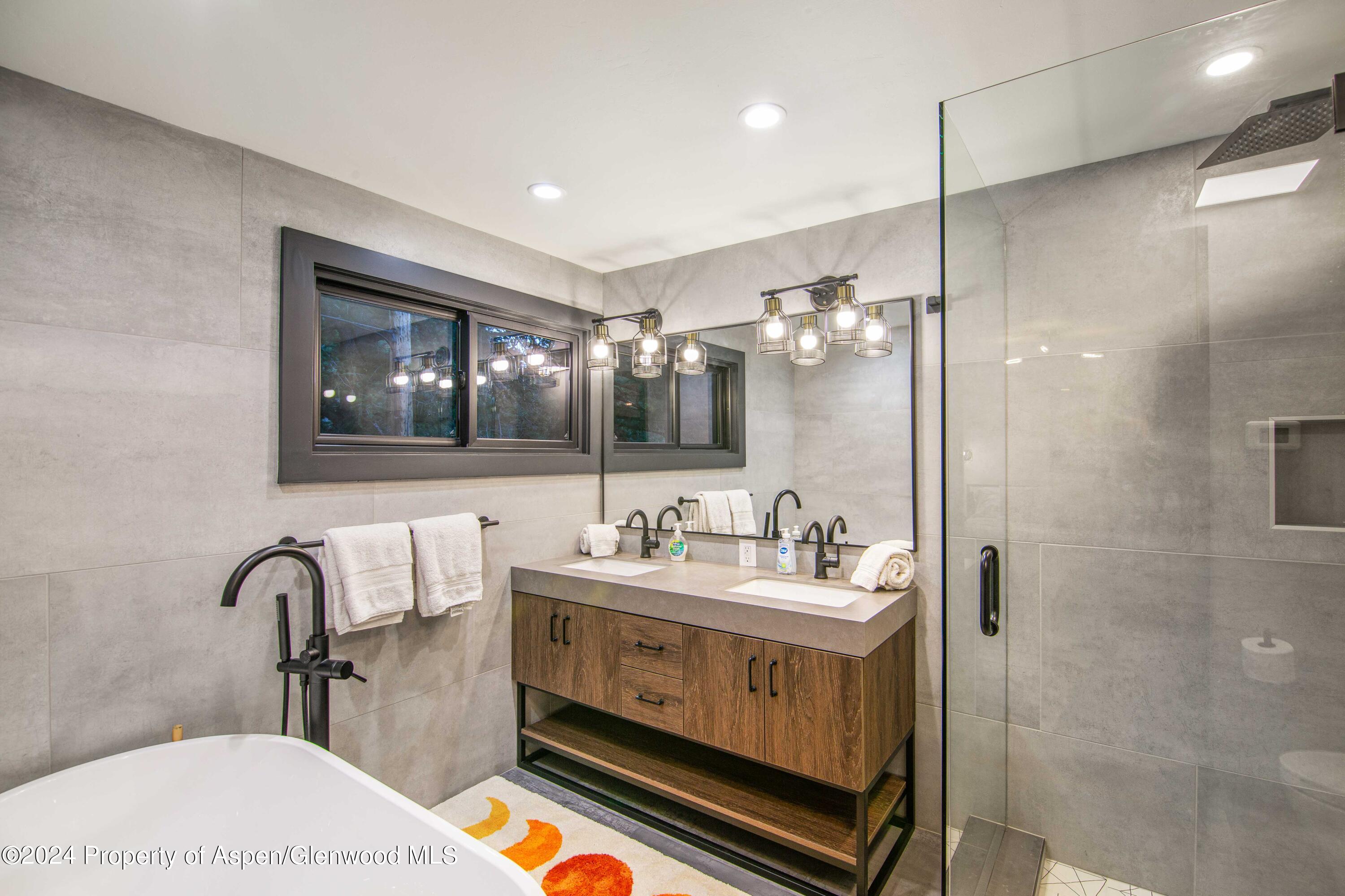 1501 Maroon Creek Road, Unit 6 Aspen, CO 81611 - Photo 40 of 48 a bathroom with a double vanity sink mirror and shower