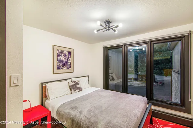 a bedroom with a bed and a chandelier