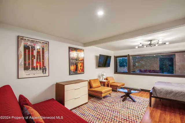 a living room with furniture a flat screen tv and a window