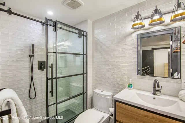 a bathroom with a sink mirror vanity and toilet