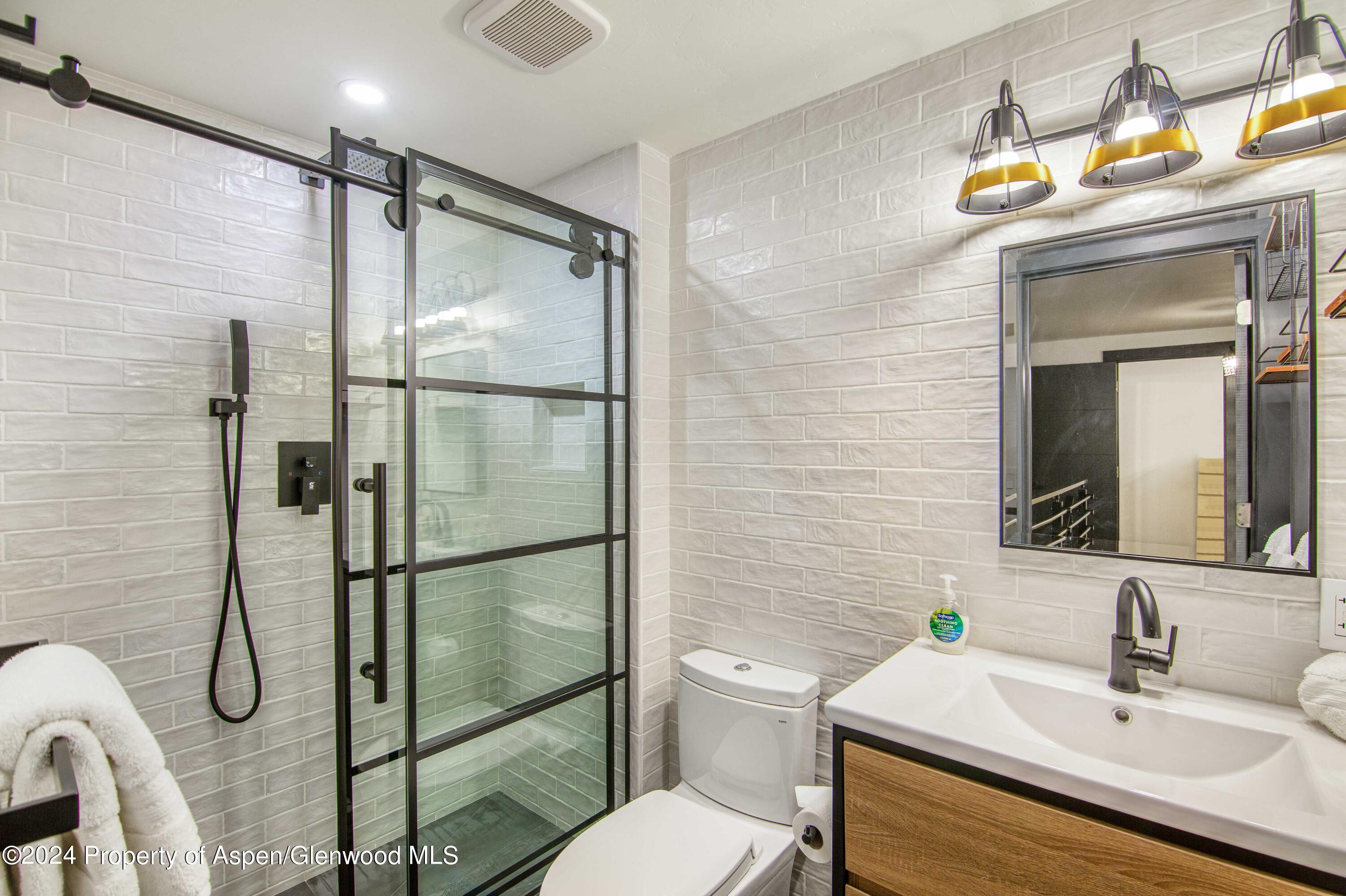 1501 Maroon Creek Road, Unit 6 Aspen, CO 81611 - Photo 45 of 48 a bathroom with a sink mirror vanity and toilet
