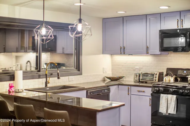 a kitchen with kitchen island granite countertop a sink stainless steel appliances and cabinets