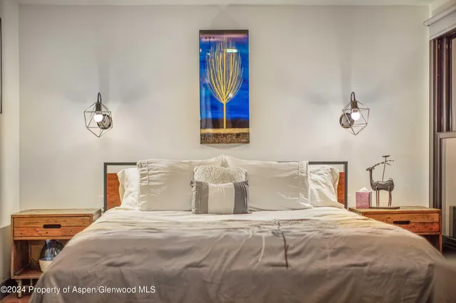 a bedroom with a bed and painting on the wall