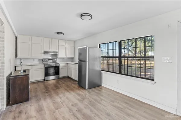 an empty room with wooden floor and ceiling fan