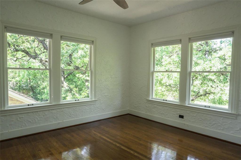 2301 Enfield Road Austin, TX 78703 - Photo 13 of 27 Empty room featuring a textured wall, dark wood-style flooring, ceiling fan, and plenty of natural light