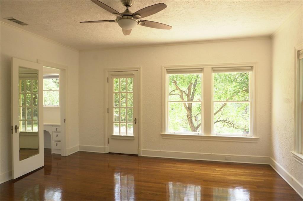 2301 Enfield Road Austin, TX 78703 - Photo 18 of 27 Empty room with a textured ceiling, healthy amount of natural light, dark wood finished floors, and a ceiling fan