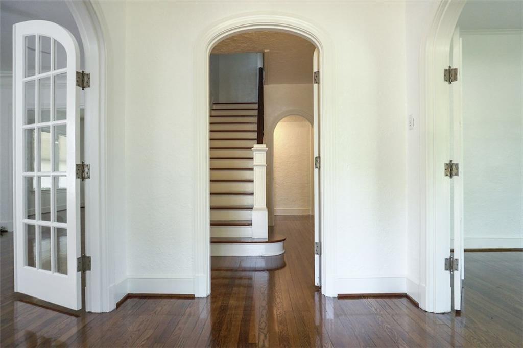 2301 Enfield Road Austin, TX 78703 - Photo 26 of 27 Hall with arched walkways, dark wood-type flooring, and stairs