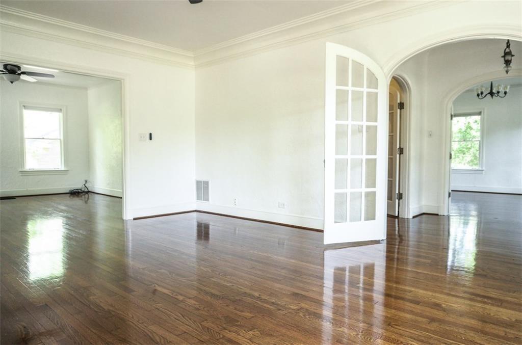 2301 Enfield Road Austin, TX 78703 - Photo 3 of 27 Spare room with dark wood-type flooring, arched walkways, ornamental molding, french doors, and a chandelier