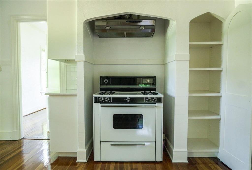 2301 Enfield Road Austin, TX 78703 - Photo 8 of 27 Kitchen featuring white range with gas stovetop, dark wood finished floors, under cabinet range hood, and white cabinets