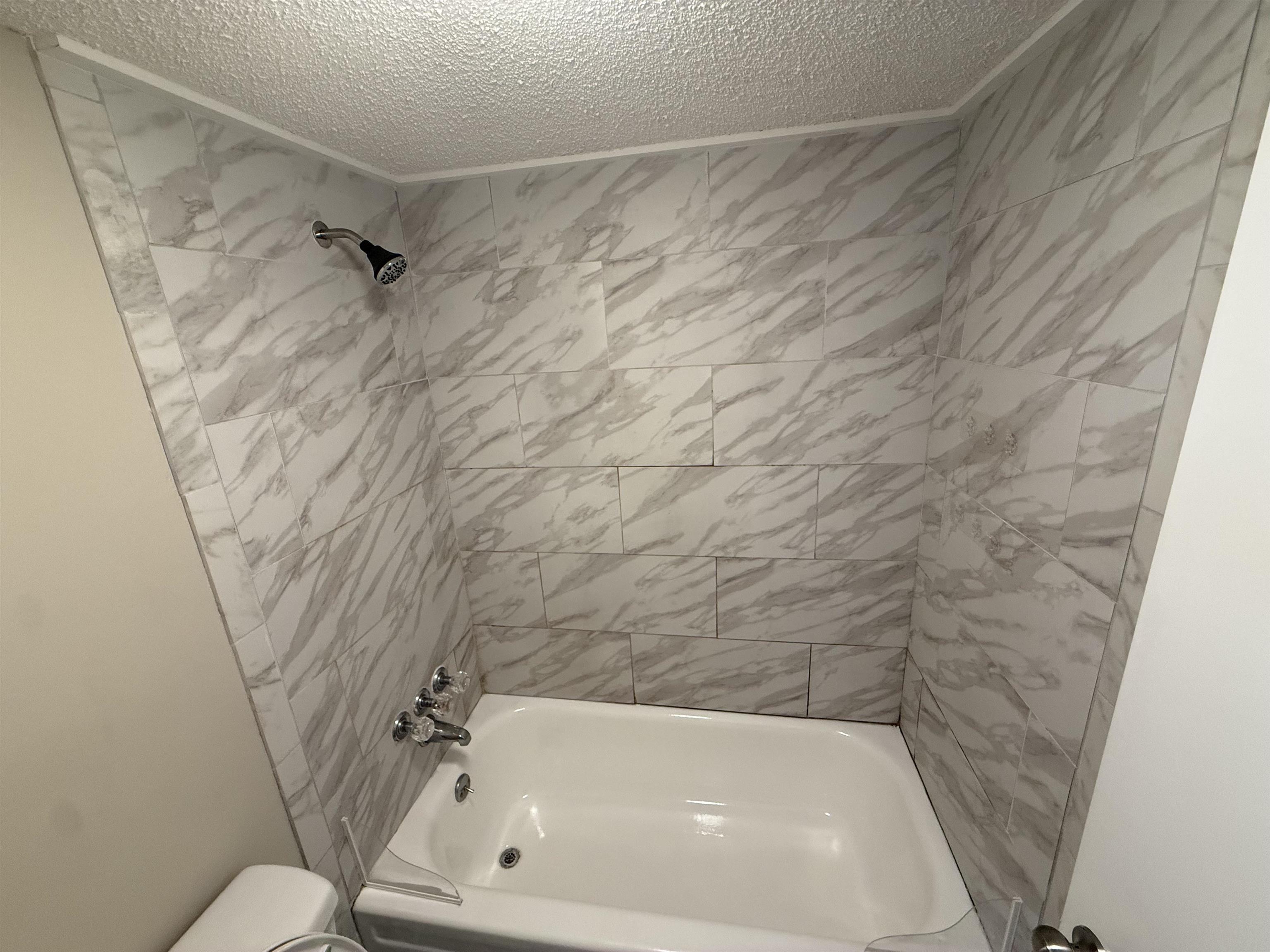 3084 Rising Sun Road, Unit 68 Lakeland, TN 38002 - Photo 7 of 13 Subway tile shower surround with a natural stone pattern
