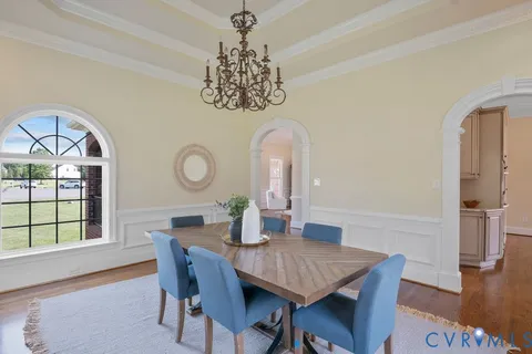 a kitchen with stainless steel appliances granite countertop a refrigerator a stove a sink dishwasher and white cabinets with wooden floor