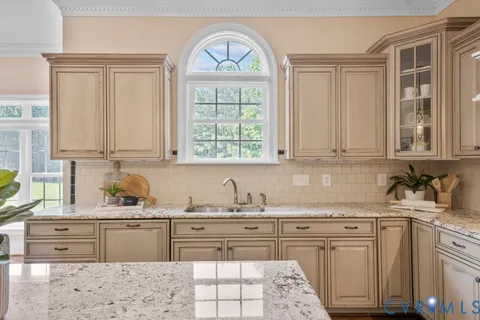 a kitchen with stainless steel appliances granite countertop a potted plant on the granite counter tops and a window