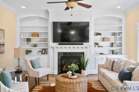 a living room with furniture a fireplace and a flat screen tv