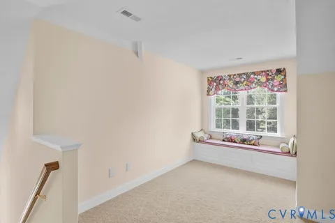 an empty room with a fan & a window