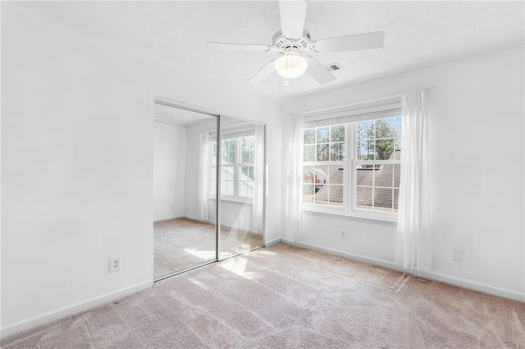 562 Windcroft Circle Northwest Acworth, GA 30101 - Photo 17 of 25 an empty room with chandelier fan and windows
