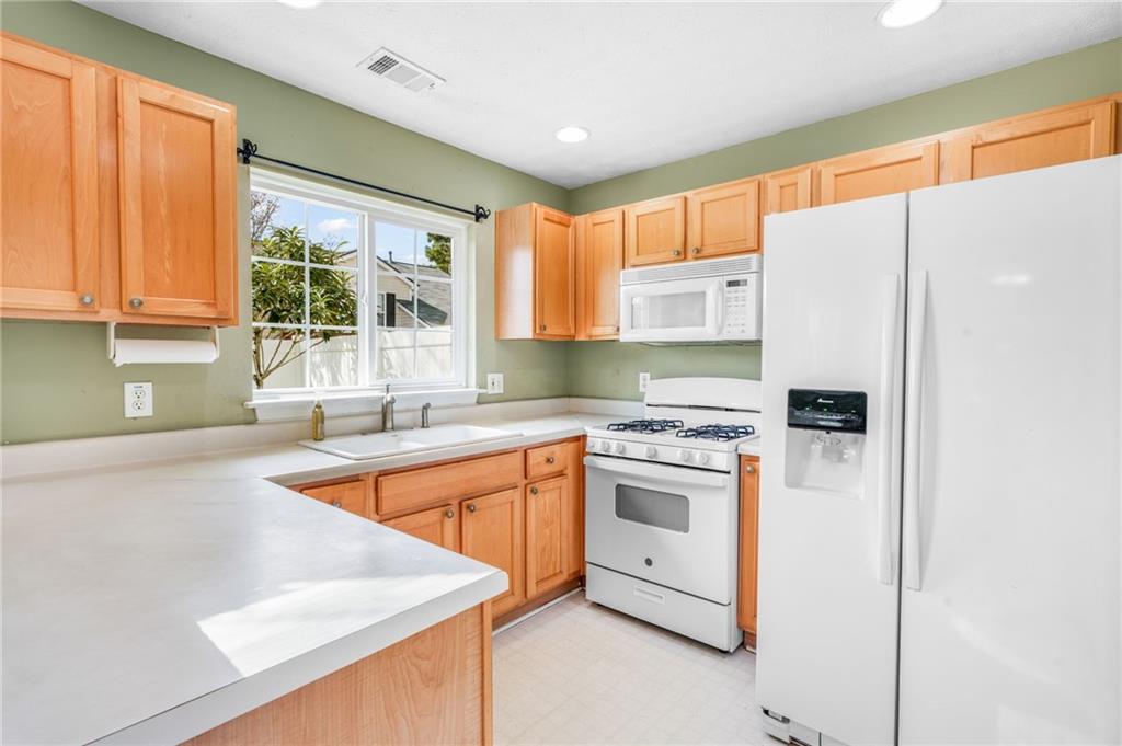 562 Windcroft Circle Northwest Acworth, GA 30101 - Photo 6 of 25 a kitchen with stainless steel appliances granite countertop a refrigerator sink and stove
