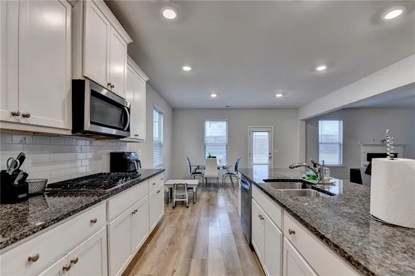 a large kitchen with granite countertop lots of counter space sink and cabinets