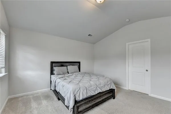 a bed sitting in a bedroom next to a bathroom