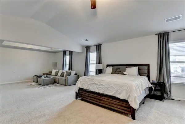 a bedroom with bed couch and window