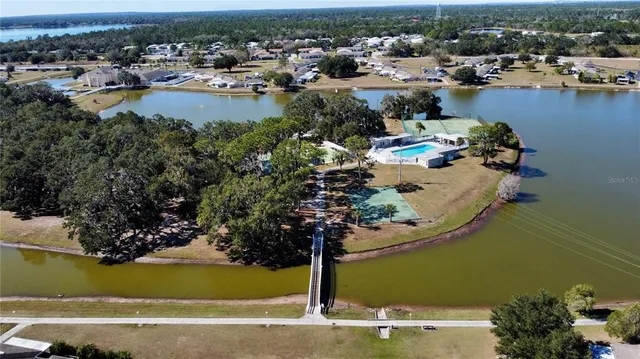 an aerial view of a house with a garden and lake view