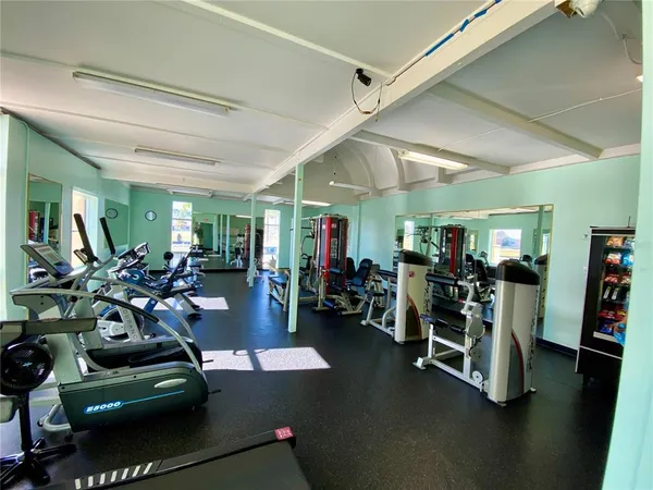 a gym room with furniture gaming gym equipment and a large window