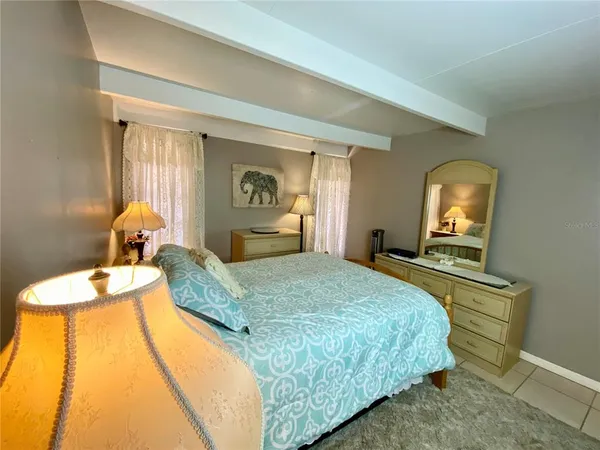 a bedroom with a bed and dresser with mirror