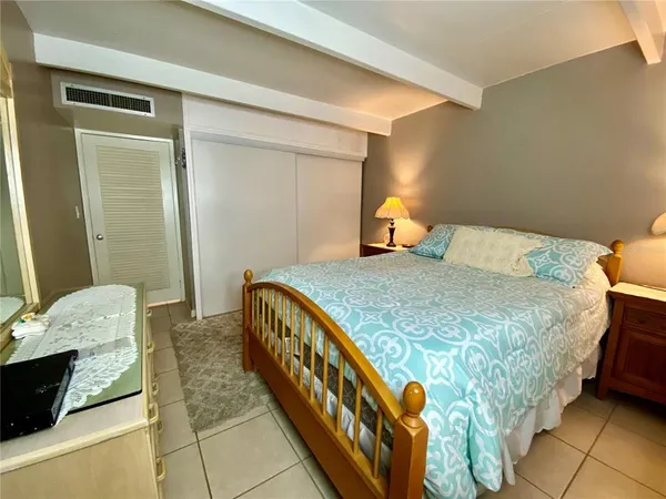 a bed sitting in a bedroom next to a window with a dresser