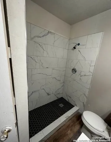 a bathroom with a toilet and a shower