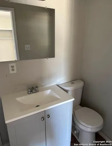 a bathroom with a sink a toilet and a mirror