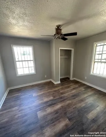 an empty room with windows and wooden floor
