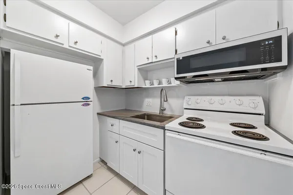 a kitchen with appliances a microwave and cabinets