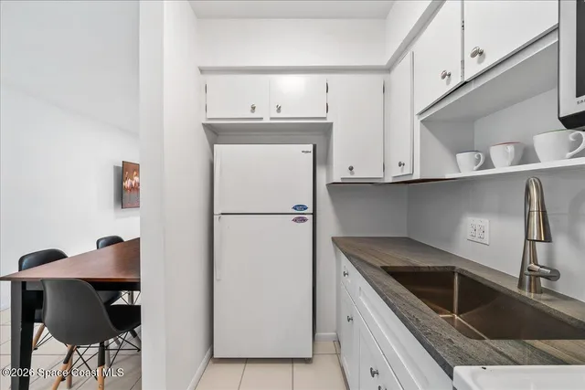 a kitchen with a sink a refrigerator and cabinets