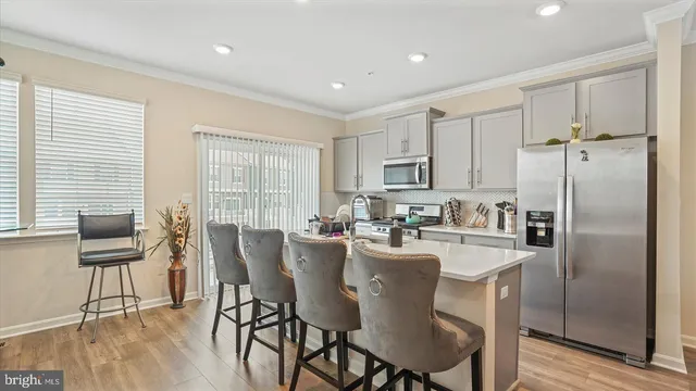 a kitchen with sink a refrigerator and chairs