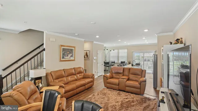 a living room with furniture a flat screen tv and a large window