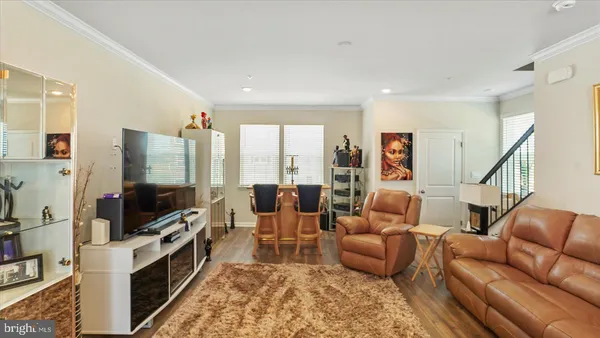 a living room with furniture flat screen tv and a view of kitchen