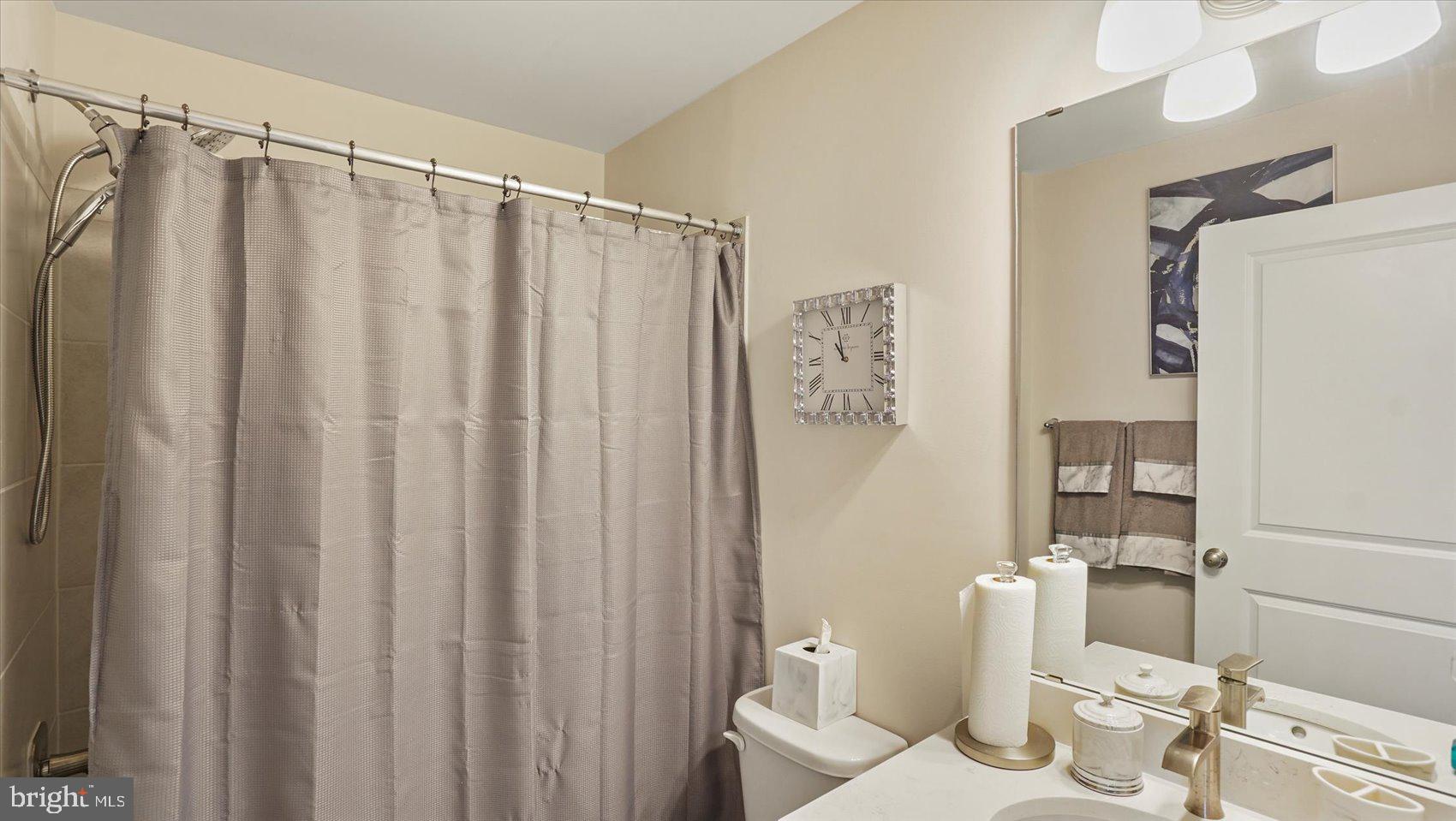 5085 Silver Oak Drive Rosedale, MD 21237 - Photo 29 of 48 a bathroom with a shower curtain and a sink