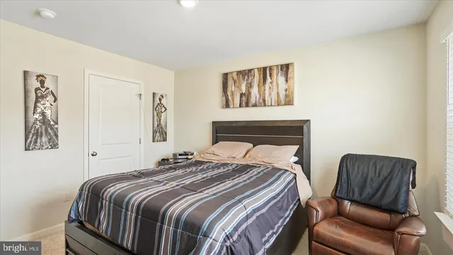 a bedroom with a bed two couch and a window