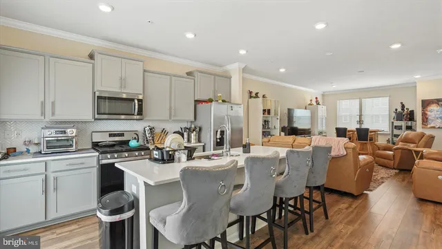a kitchen with counter space appliances and a view of living room