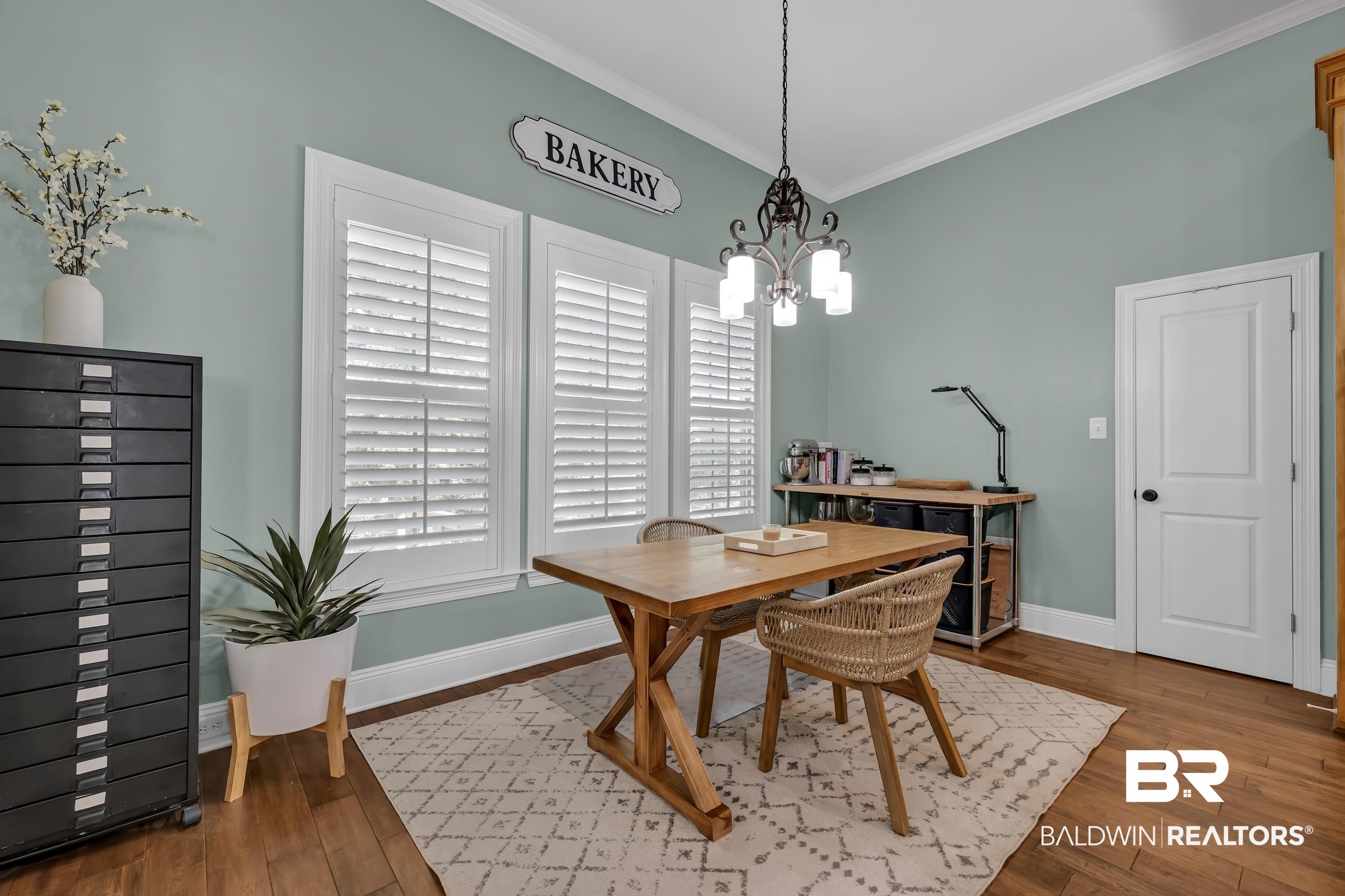 8137 Pine Run Daphne, AL 36527 - Photo 22 of 67 Interior space featuring wood-finish flooring, white crown molding, and a paneled door with dark hardware