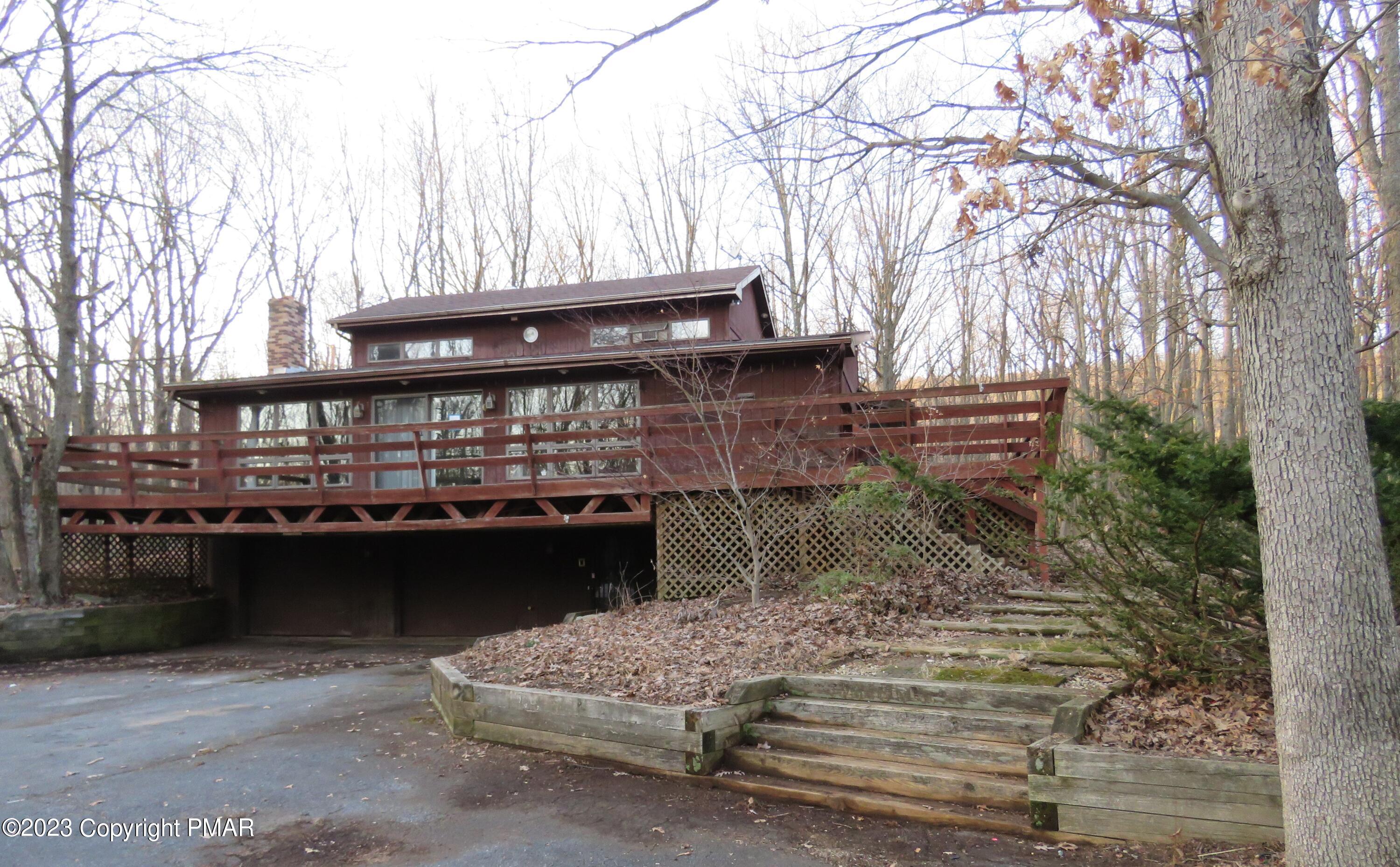 a view of house with roof deck and wooden fence