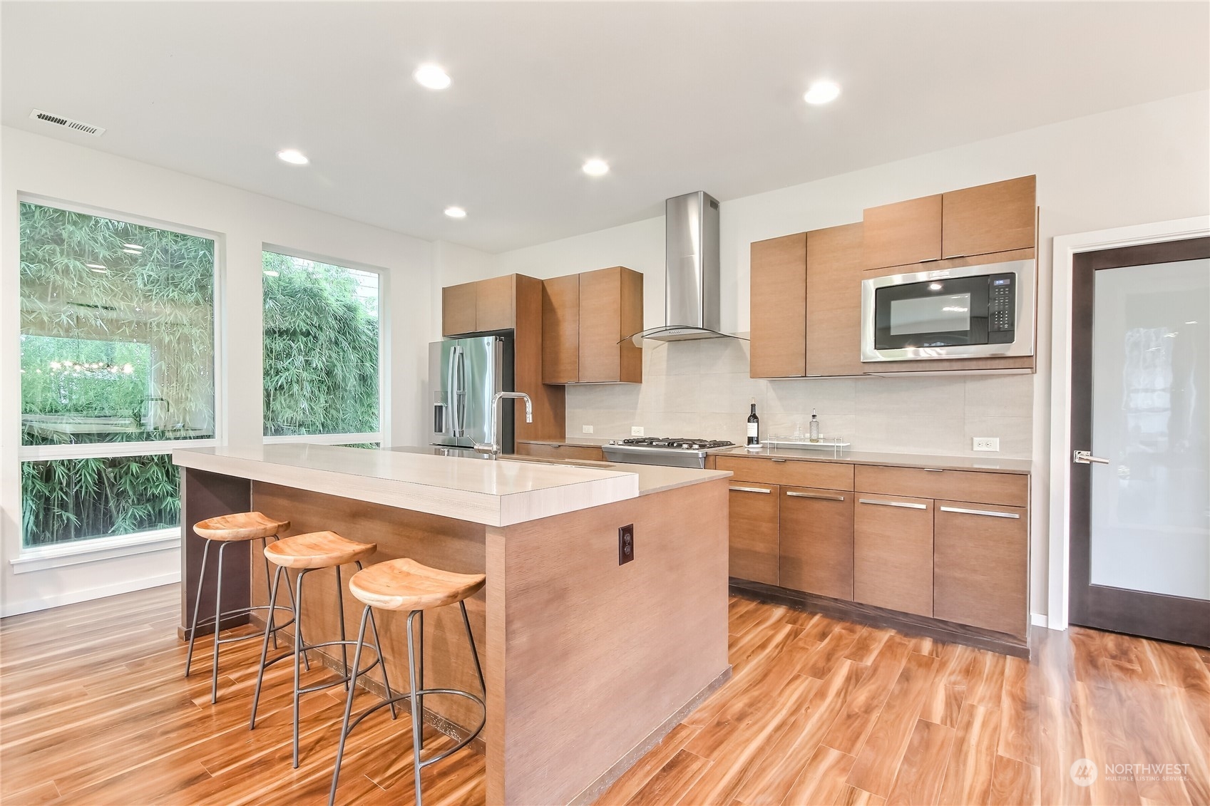 3822 Northeast 24th Court Renton, WA 98056 - Photo 9 of 37 a kitchen with stainless steel appliances granite countertop a stove a sink dishwasher a microwave oven and a dining table with wooden floor