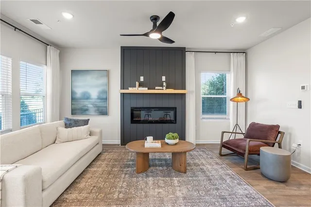 a kitchen with stainless steel appliances granite countertop a refrigerator a stove a sink a dining table and chairs with wooden floor