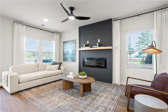 a living room with stainless steel appliances furniture and a kitchen view